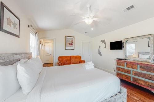 a white bedroom with a bed and a ceiling fan at Sunsets At Joe's in St. George Island