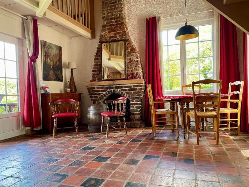 une salle à manger avec une table et des chaises et une cheminée dans l'établissement Les Cottages d'Orient Gite Boutique, à Mesnil-Saint-Père