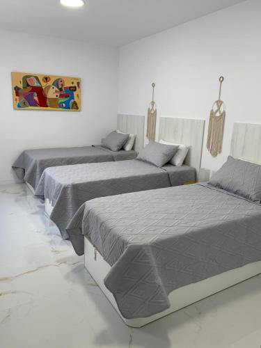 three beds in a white room with at Apartamento Casa Blanca in Las Palmas de Gran Canaria