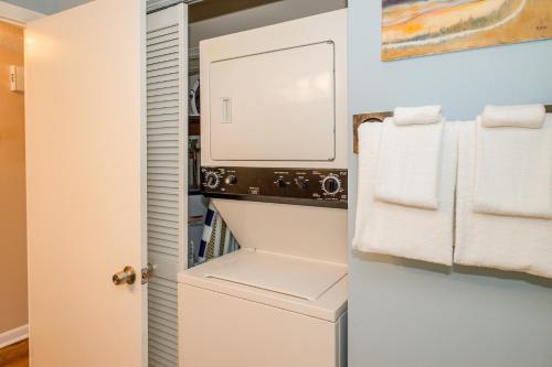 a small closet with a white refrigerator and towels at What A View in Carolina Beach