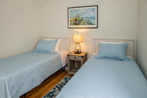 a bedroom with two beds and a table with a lamp at What A View in Carolina Beach