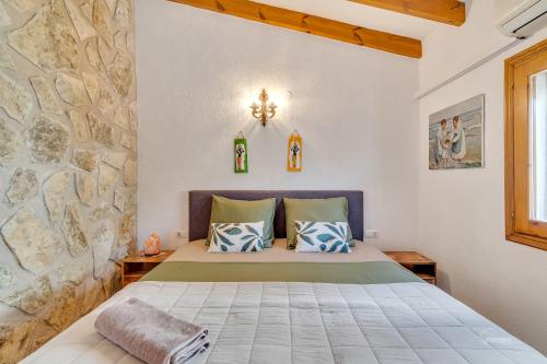 een slaapkamer met een bed en een stenen muur bij Casa Llibertat boutique stay with spa in Lliber