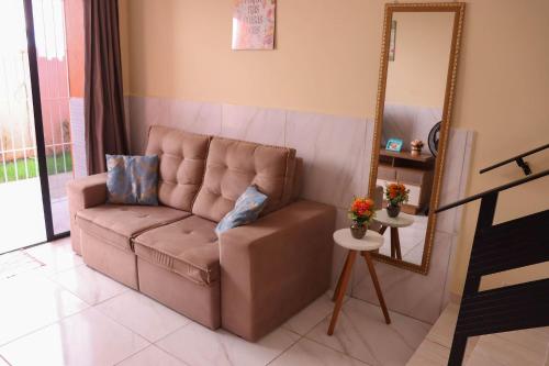 a brown couch in a living room with a mirror at Casa Lua Nova na Praia de Peroba, Maragogi in Maragogi