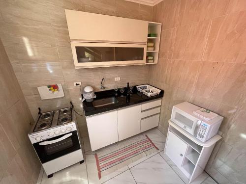 a small kitchen with a sink and a microwave at Casa Lua Nova na Praia de Peroba, Maragogi in Maragogi