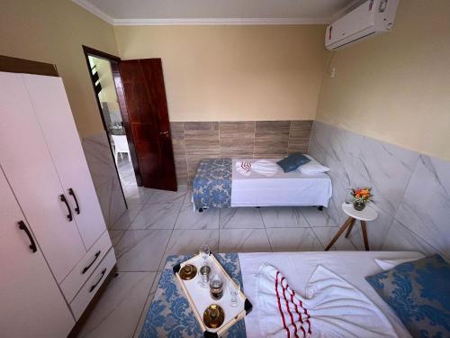 a small bedroom with two beds and a sink at Casa Lua Nova na Praia de Peroba, Maragogi in Maragogi