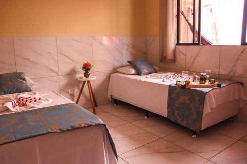 a bedroom with two beds and a table with dolls on them at Casa Lua Nova na Praia de Peroba, Maragogi in Maragogi