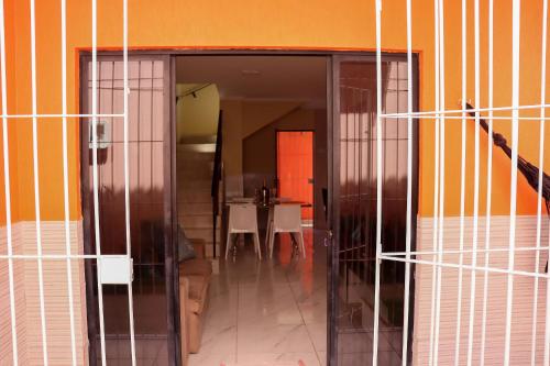 an open glass door to a room with a table at Casa Lua Nova na Praia de Peroba, Maragogi in Maragogi