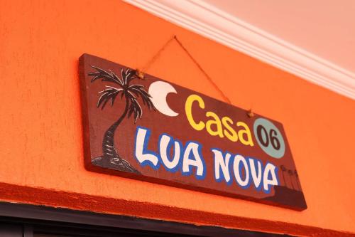 a sign on the side of a building with a palm tree at Casa Lua Nova na Praia de Peroba, Maragogi in Maragogi