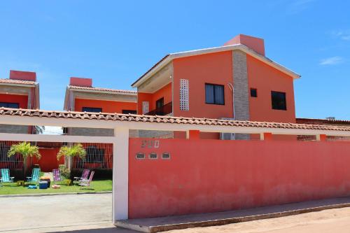 a house with a red fence in front of it at Casa Lua Nova na Praia de Peroba, Maragogi in Maragogi