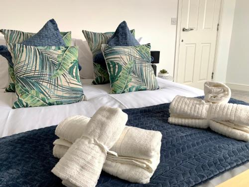 Una cama con almohadas azules y blancas y toallas. en LOVELY STYLISH APARTMENT NEAR PENNY LANE! FREE PARKING en Liverpool