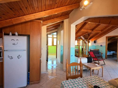 a kitchen and a living room with a refrigerator at Loft apartment 20m from sea in Melission