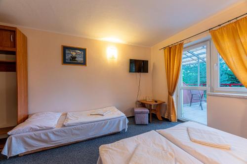 Habitación de hotel con 2 camas y ventana en Penzion Adak, en Párnica