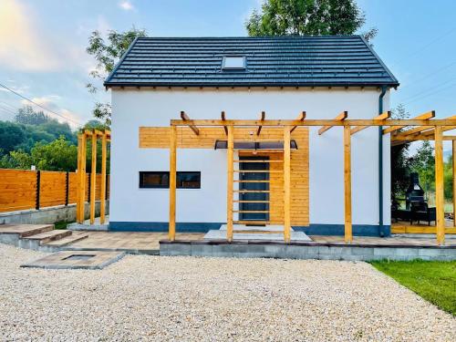 a small white building with a wooden structure at Chalet Alteo in Buşteni