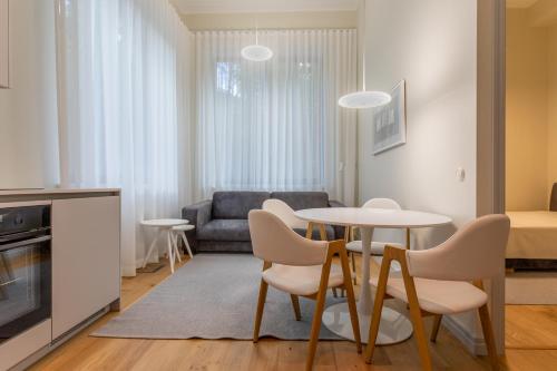 een woonkamer met een tafel en stoelen en een bank bij Vallikraavi Lux Apartment in Tartu