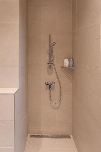 a shower with a shower head in a bathroom at Vallikraavi Lux Apartment in Tartu