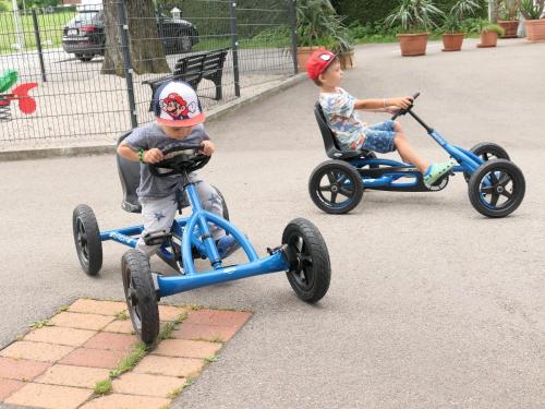 two young children riding on toy tricycles at Landgasthof Spitzerwirt in Sankt Georgen im Attergau