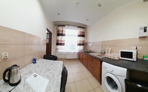 eine Küche mit einer Waschmaschine und einer Mikrowelle in der Unterkunft HOTEL RADOMSKO in Radomsko