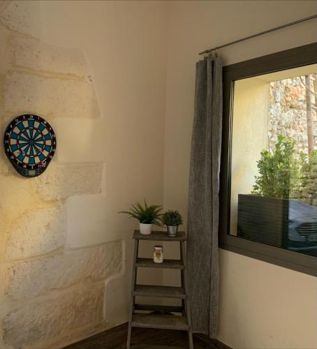 une chambre avec un tableau de fléchettes sur le mur et une fenêtre dans l'établissement L'Hospitalet, à Lansargues