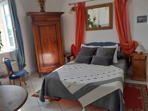 1 dormitorio con cama, mesa y espejo en Studio De La Mer, en Arromanches-les-Bains