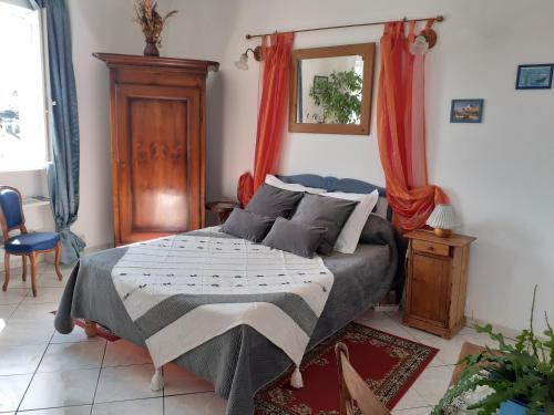 a bedroom with a bed with red curtains at Studio De La Mer in Arromanches-les-Bains