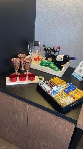 a table with two trays of food and wine glasses at QS Marista - Studio Alessandra Antonelli - flat 1701 in Goiânia