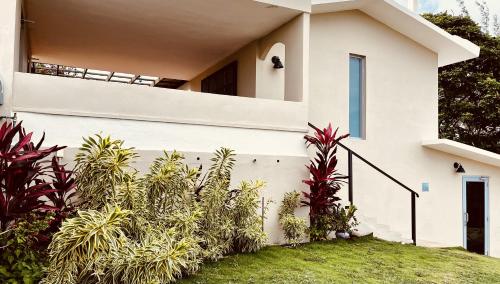 a white house with plants in front of it at Lejos Eco Retreat in Vieques