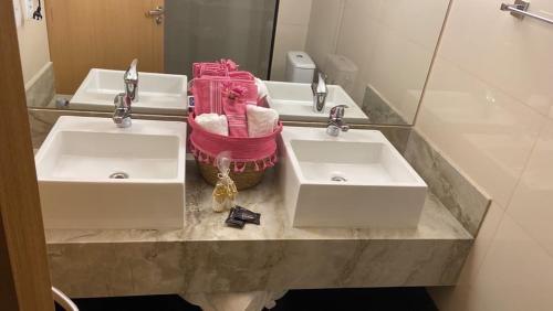 uma casa de banho com dois lavatórios e dois espelhos em QS Marista - Studio Alessandra Antonelli - flat 1701 em Goiânia