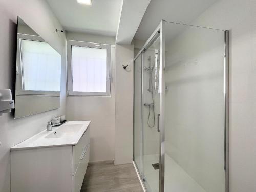 baño blanco con ducha y lavamanos en Apartamento cerca del mar, en Alicante