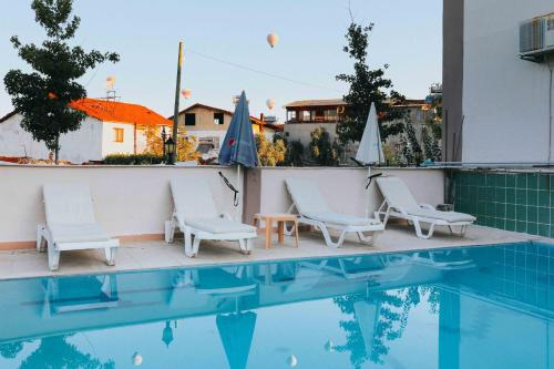 a group of chairs and a swimming pool at Kervansaray Hotel in Pamukkale