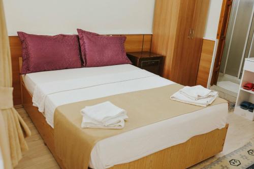 a bedroom with a large bed with towels on it at Kervansaray Hotel in Pamukkale