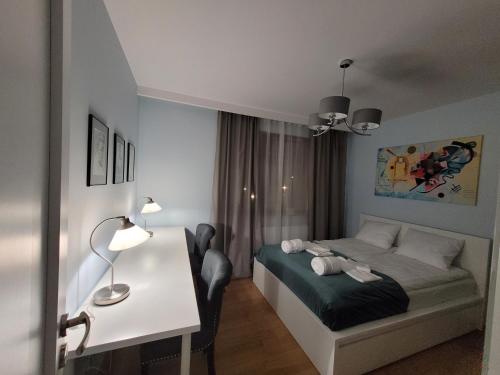 sypialnia z łóżkiem i biurkiem z lampką w obiekcie Warsaw Praga Apartment w Warszawie