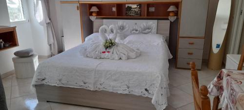 a bedroom with a white bed with rabbitsitures on it at La Necussella in Anacapri