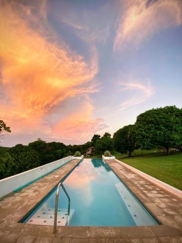 a swimming pool with a sunset in the sky at Lejos Eco Retreat in Vieques