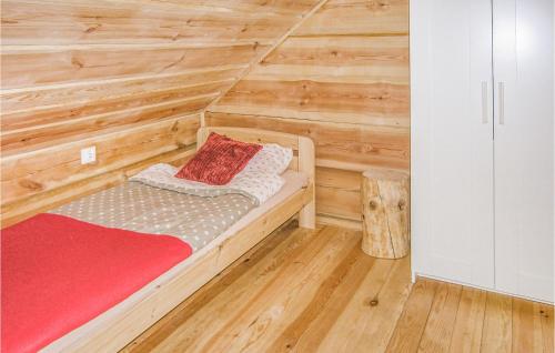 a small bedroom with a wooden wall at Cozy Home In Biskupiec With Kitchenette in Biskupiec