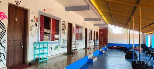 a hallway of a school with paintings on the walls at HosteLife Gokarna in Gokarna