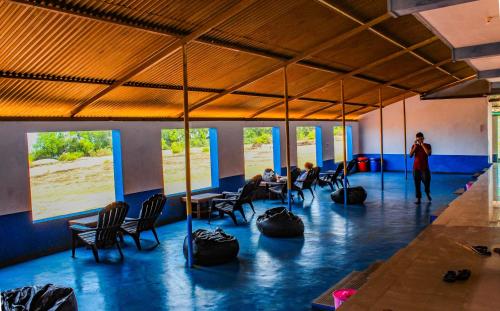 a room with people sitting at tables and chairs at HosteLife Gokarna in Gokarna