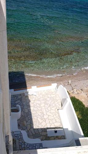a white bench on the beach near the water at Ma mer in Naxos Chora