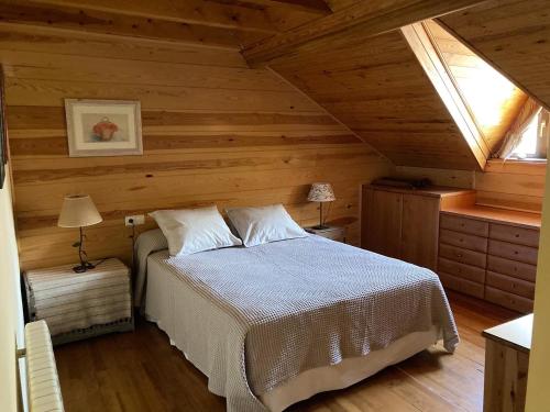 a bedroom with a bed in a wooden cabin at El Cau de Cal Quimet in Rialp