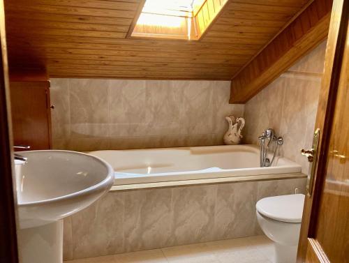 a bathroom with a tub and a sink and a toilet at El Cau de Cal Quimet in Rialp