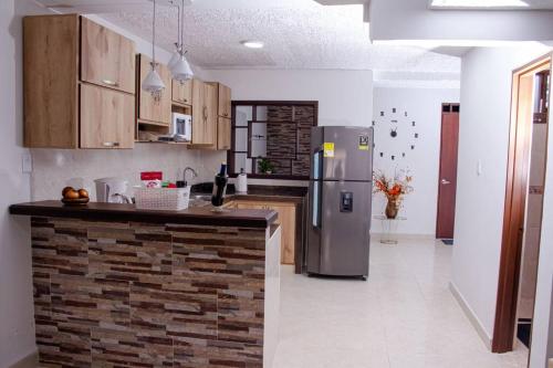 a kitchen with a stainless steel refrigerator and a counter at Apartamento confortable, cerca a la Basílica in Buga