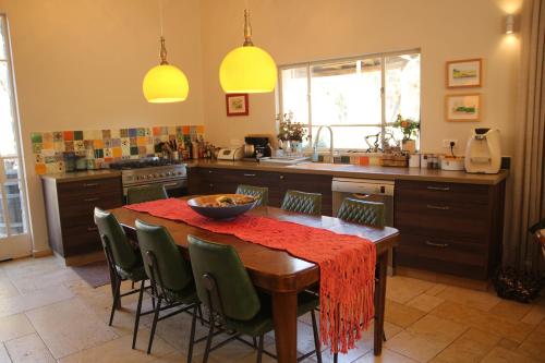 eine Küche mit einem Holztisch mit Stühlen in der Unterkunft Villa Dadia - Rosh Pina in Rosch Pina