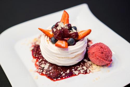 a dessert on a white plate with carrots and blueberries at GLAMOUR - Restaurant & SPA in Przeźmierowo
