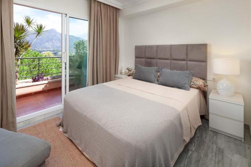 1 dormitorio con 1 cama grande y balcón en Nueva Andalucia Magna Marbella Golf, en Marbella