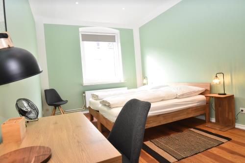 een slaapkamer met een bed, een bureau en een tafel bij fewo1846 - Stadtbude - komfortable 2-Zimmer-Wohnung mitten im Stadtzentrum in Flensburg