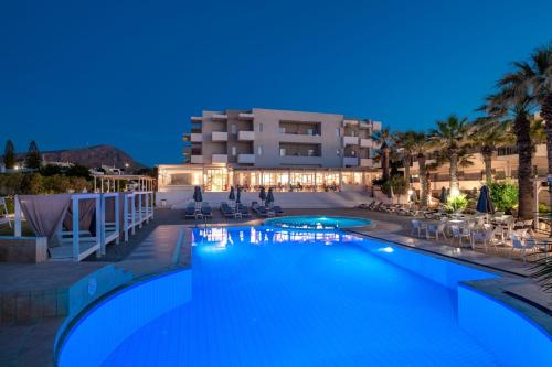a swimming pool in front of a hotel at night at Gouves Bay by Omilos Hotels in Gouves