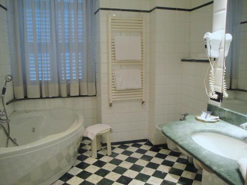 a bathroom with a tub and a sink at Hotel Due Mondi in Turin