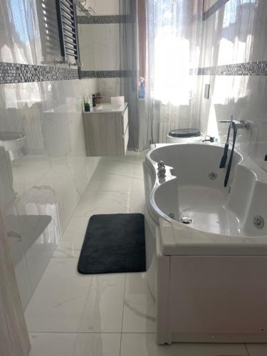 ein weißes Badezimmer mit einem Waschbecken und einer Badewanne in der Unterkunft Appartamento Mire&Geo in Voghera