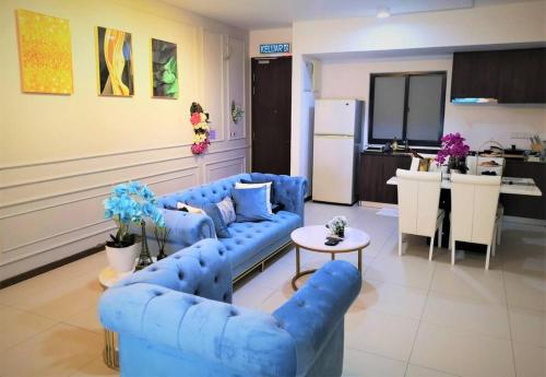 uma sala de estar com sofás azuis e uma cozinha em 皇家海景ROYAL Luxury Seaview Room, 3 minute to Gurney em Tanjong Tokong