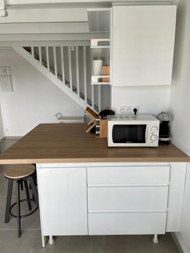 a kitchen with a counter top with a microwave at Appartement Marina de Saint-François in Saint-François