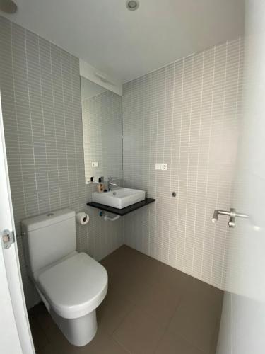 a bathroom with a white toilet and a sink at Calagrande in Almería